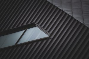 A sleek metal rooftop with a unique window, showcasing modern architectural style and geometric patterns.